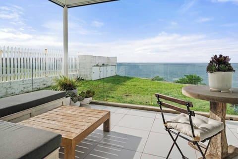Breathe in the ocean breeze from this cliffside perch—glass panels keep the view clear while you dine alfresco or sip wine as the sun sets.