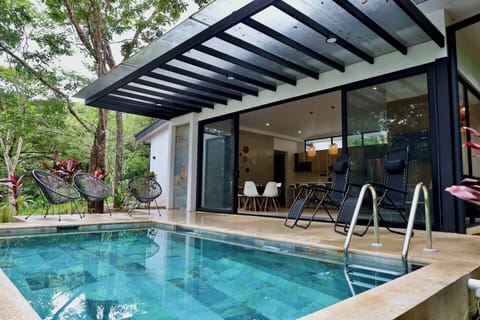 An outdoor oasis complete with a private pool, outdoor shower, & double patio doors leading into the main social area of the home.