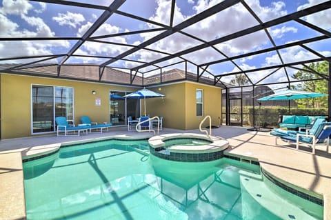 Relax by the screened pool and spa area with comfortable seating and umbrellas.