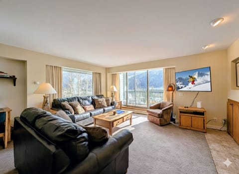 Unwind in your spacious living room where plush leather seating and mountain views create the perfect après-ski retreat.