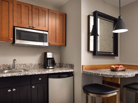 Kitchenette with microwave, small frig, kitchenware, and cafe seating for two 