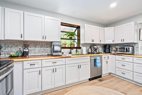 Bright, spacious, and fully stocked, this kitchen is ready for anything from morning coffee to evening meals. Enjoy cooking with modern appliances and plenty of counter space, all while looking out at the surrounding greenery.
