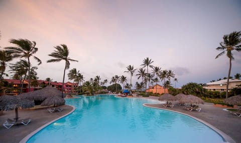 Slip into sunset serenity beside the palm-lined lagoon pool.