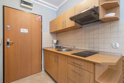 Wooden and functionally equipped kitchenette with a toaster, a coffee machine, and a kettle.