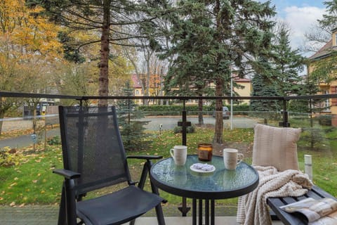 Furnished balcony with green surroundings. 
