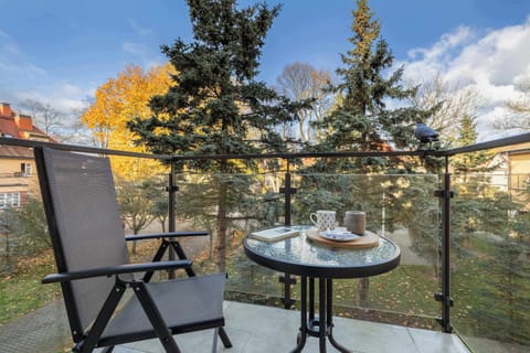 Furnished balcony with green surroundings.