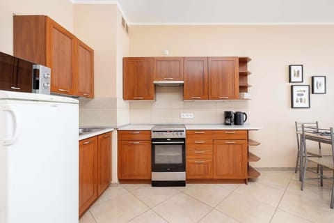 A functional kitchen with brown-coloured furniture, which includes accessories and utensils that will be indispensable when preparing meals.
