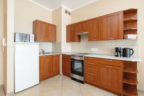 A modern kitchen with brown-colored cabinets, an oven, and an induction stove.