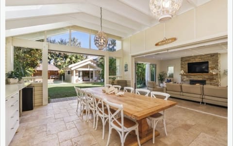 Outdoor/undercover kitchen and dining area overlooking pool and gardens