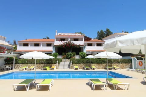 Unwind poolside with shady umbrellas and serene garden views.