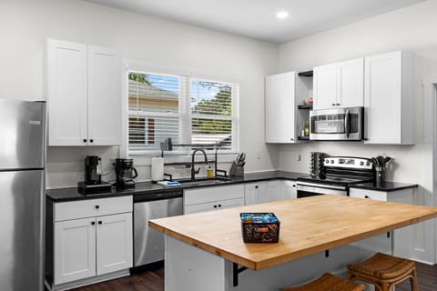 The open floor plan kitchen is fully equipped with stainless steel appliances -refrigerator, stovetop and over, coffee maker, toaster, microwave, and dishwasher — everything you need for a convenient and comfortable stay.