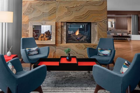 Cozy fireplace corner with blue chairs and wood log display