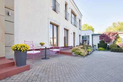 A charming outdoor courtyard with colorful flower pots and well-maintained paving. This area offers a beautiful and tranquil setting for relaxation, perfectly complementing the modern building.