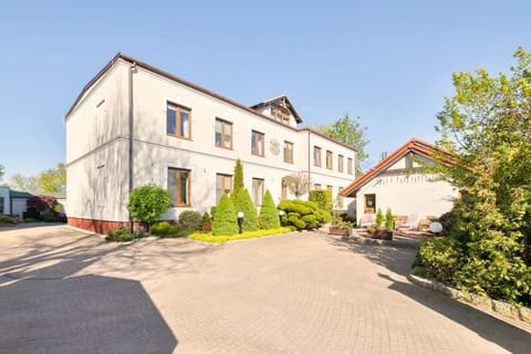 A grand building surrounded by greenery and cobblestone paths.
