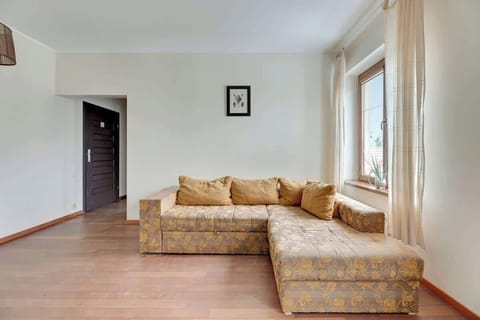 A bright living room with a comfortable sofa, a wooden coffee table, and soft lighting, creating a relaxing space for unwinding.