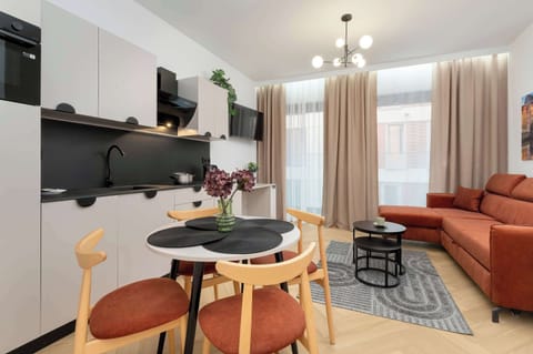 The bright living area with a comfortable sofa and kitchenette invites you to cook together and relax in natural light.