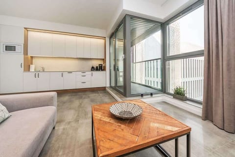 A spacious and stylish living room that seamlessly combines comfort and modern design. It features a cozy gray sofa bed, perfect for daytime relaxation and nighttime rest