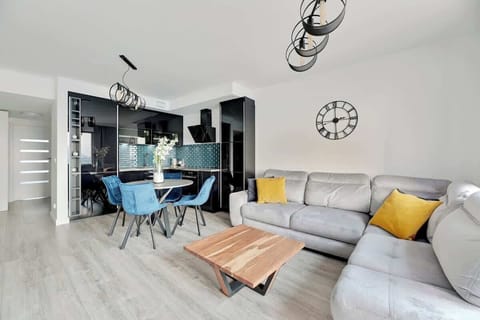 Sleek modern design with stylish accents, featuring a comfortable sofa, elegant dining area, and a vibrant kitchen, creating a welcoming and sophisticated atmosphere.