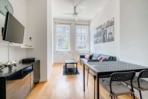 The modern-style living room is characterized by bright colors, minimalist design and a cozy atmosphere, highlighted by wooden floors and large windows.
