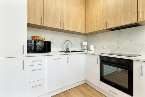 Bright and functional kitchen with white lower cabinets and modern appliances. Designed with clean lines and simplicity in mind.