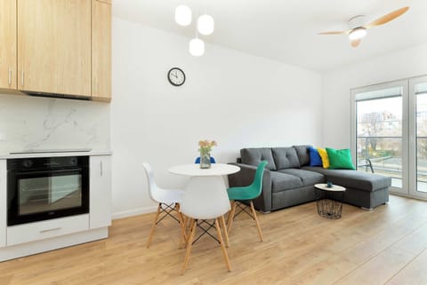 Bright living room with a stylish fireplace, white walls, and green and turquoise decor accents. A great place to relax or enjoy time with friends and family.