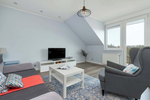 A spacious living room with large windows brings in plenty of natural light and a relaxing atmosphere.