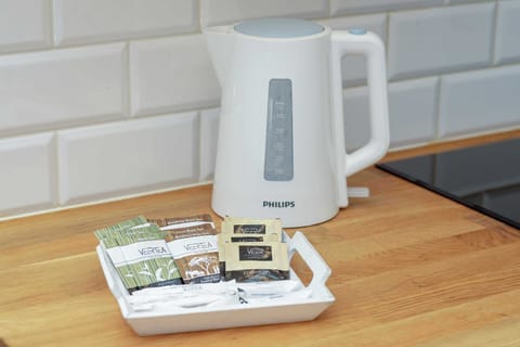  A countertop scene with a kettle, tray of tea and coffee supplies, creating a welcoming touch.
