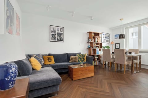 Bright living room with a corner sofa, wooden coffee table, and art-filled walls.