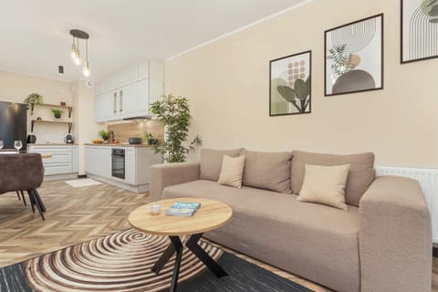 A sofa with cushions and a side table holding a decorative lamp, adding a warm touch to the space.