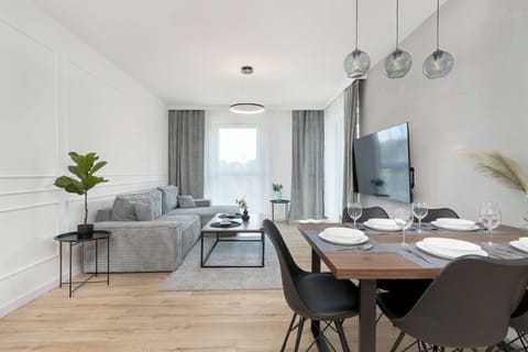 Living room with sofa bed, Smart TV and dining area.