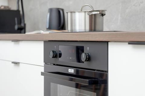 Fully equipped kitchenette with induction cooktop, oven, electric kettle, coffee maker.