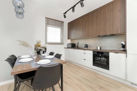 Fully equipped kitchenette with induction cooktop, oven, refrigerator with freezer, microwave oven and dining area.