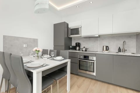 A modern kitchen with a dining table for 6 people, ideal for a family dinner together.