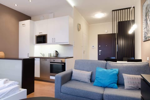 Another perspective of the living room with a comfortable seating area, shelves, and decorative artwork on the wall.
