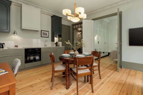 Another angle of the dining space, highlighting the round table set for a meal under a traditional chandelier.