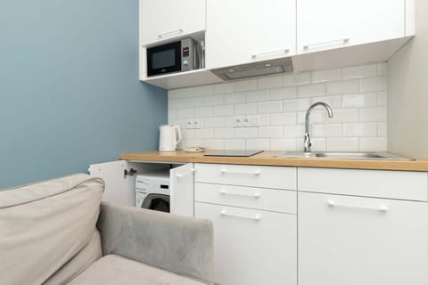 Kitchenette with wooden countertop and built-in microwave.