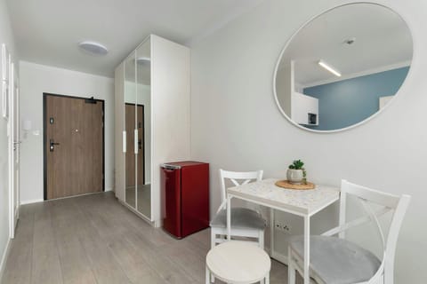 Entry area with elegant round mirror and neat dining setup.