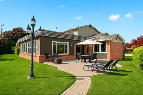 Soak up the sun in this spacious backyard retreat featuring a patio dining set, fire pit, and lounge chairs for ultimate relaxation.