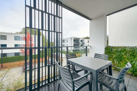 A balcony with seating, perfect for enjoying morning coffee with a view of greenery.