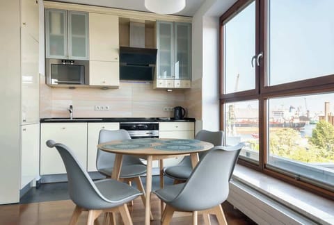 A sophisticated combination of the kitchen and dining space, bathed in natural light from expansive windows.