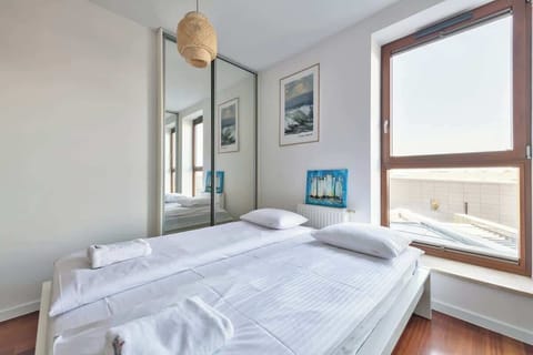 A serene bedroom with a comfortable double bed, large windows, and soft, neutral decor to enhance relaxation.