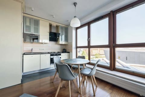 A fully equipped kitchen with sleek cabinetry and a compact dining table perfectly situated near a window for enjoying meals with a view.