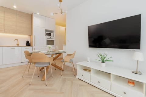 The functional kitchen open to the dining room is equipped with modern appliances: refrigerator, freezer, oven and elegant wooden cabinets, ideal for cooking and spending time with loved ones.