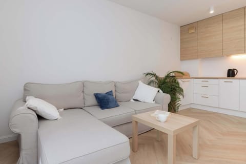 A cozy sitting area in bright colors with a soft sofa, decorative pillows and plants promotes relaxation and tranquility.