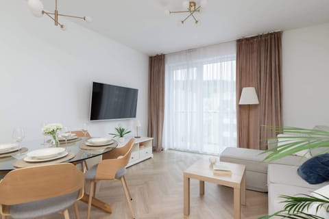 The bright and spacious living room impresses with large windows, modern decor and a comfortable dining table, creating the perfect place to relax and enjoy meals together.