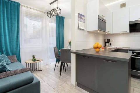 A bright, open-plan living area with a kitchen, dining table, and large windows.