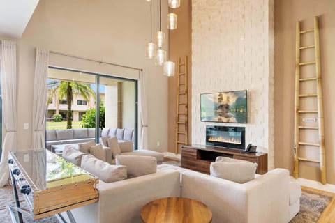 Stunning stone media wall, modern fireplace, and bright patio access.