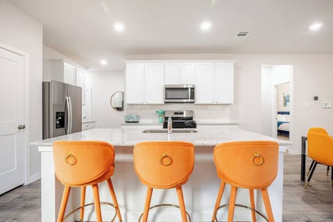 A bright dining table for 8, stylish barstools, and a sleek kitchen