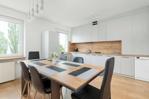 The modern kitchenette with white cabinets and wooden countertops offers a stylish and functional space for cooking.
