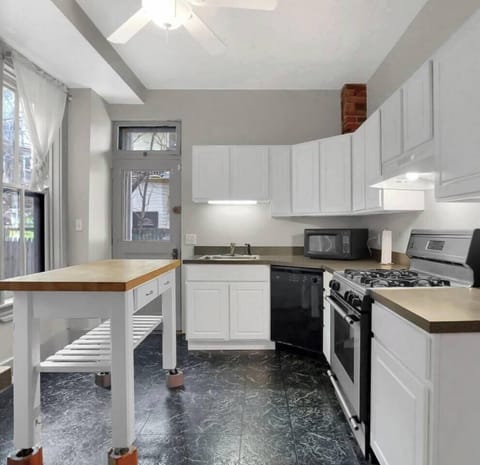 Well-equipped kitchen, leading to brick patio backyard. 